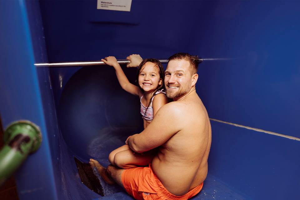 Papa mit Tochter auf der Wasserrutsche