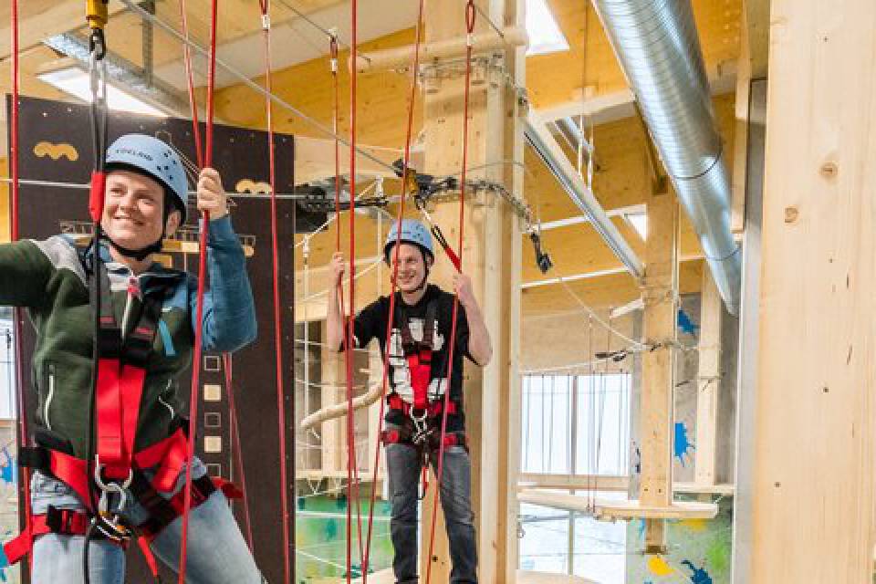 Zwei Männer mit Kletterausrüstung im Hochseilgarten der Fundorena