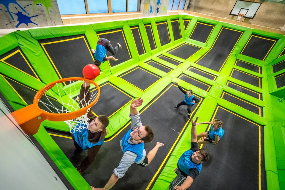 Gruppe spielt Basketball in der Trampolinhalle