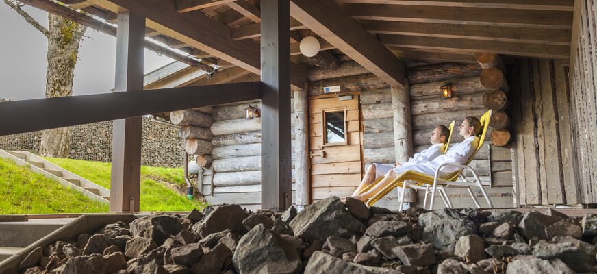 Pärchen beim Relaxen auf den Liegen vor der Sauna